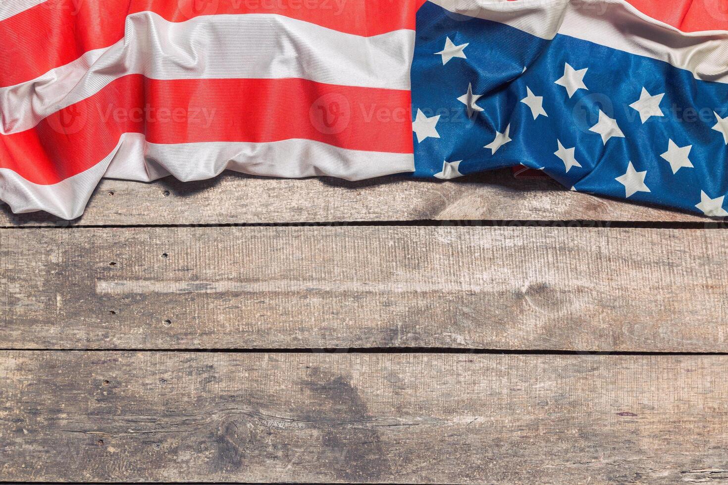 An American Flag Lying on an aged, weathered rustic wooden background photo