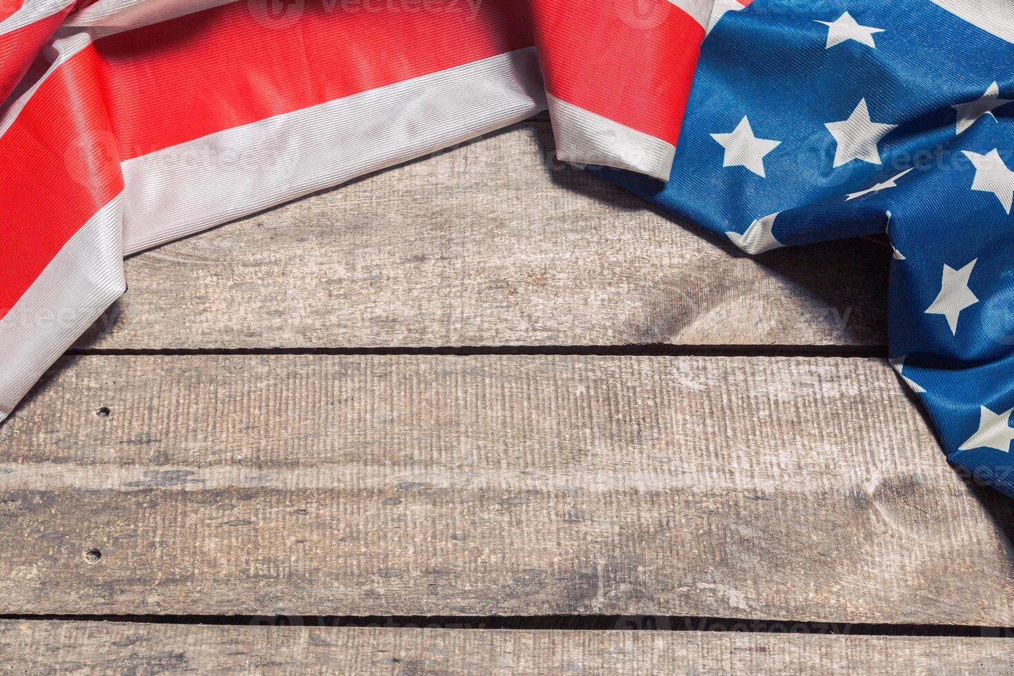 An American Flag Lying on an aged, weathered rustic wooden background photo