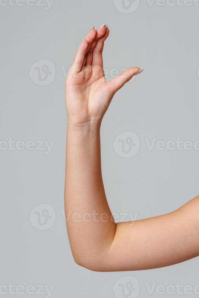 Raised hand against a neutral background in a softly lit setting photo