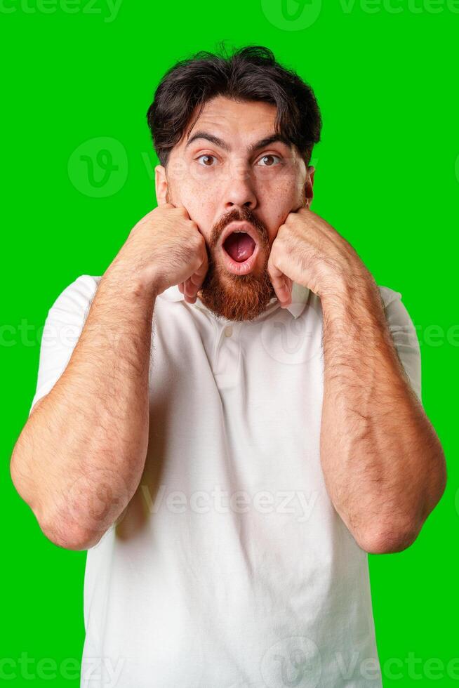 Young man expresses surprise in front of a bright green background photo