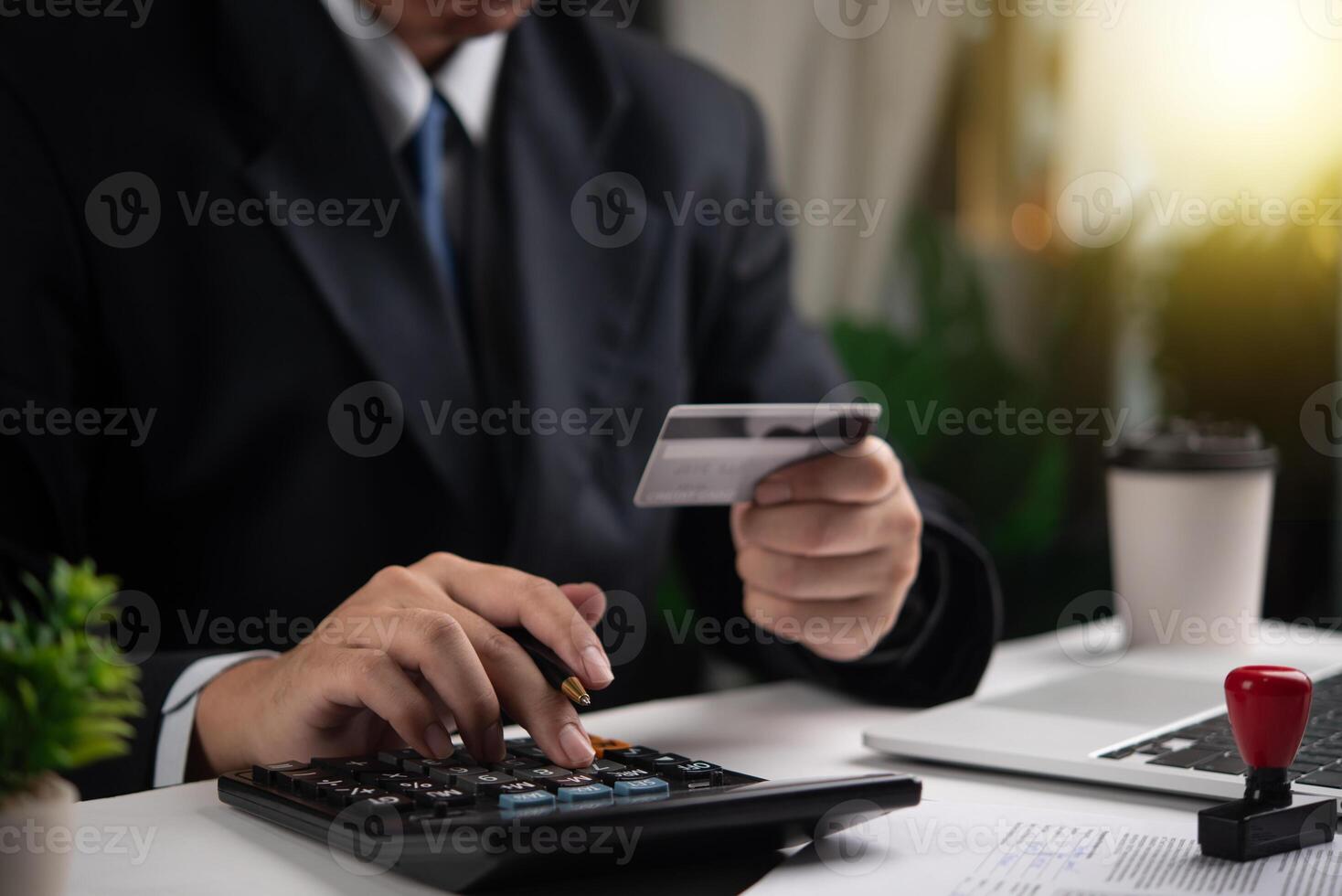 Businessman using calculator and holding credit card. Concept of finance, accounting, payment calculation. Suitable for financial services, business management. photo