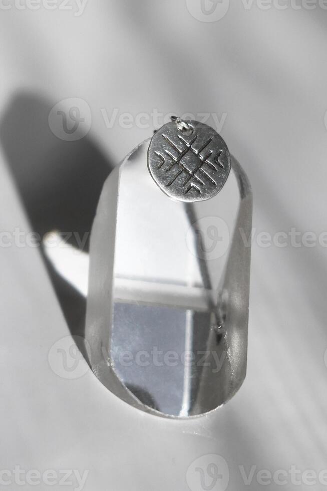 Silver round pendant with unique geometric grooved pattern. Handcraft precious item. photo