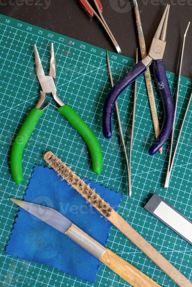 Overhead view on tools on a green cutting mat for crafting handmade jewelry things. photo