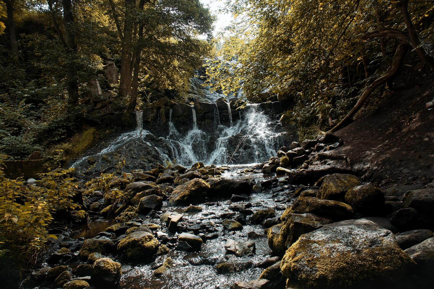 Small waterfall in Sweden in autumn. Moss-covered stones. Forest on the riverbank photo