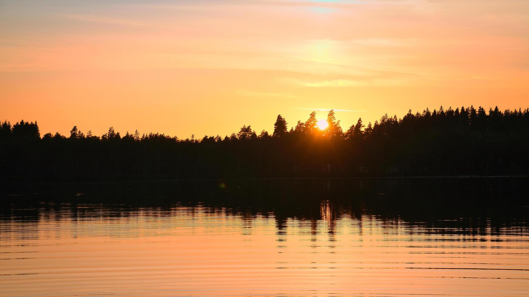 Sunset with warm colors on a Swedish lake in Smalland. Romantic evening atmosphere photo