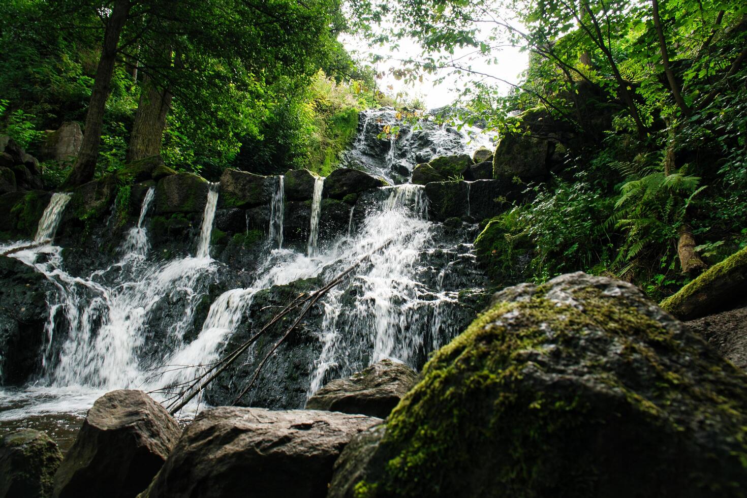 Small waterfall in Sweden. Moss-covered stones. Forest on the river bank. Scandinavian photo