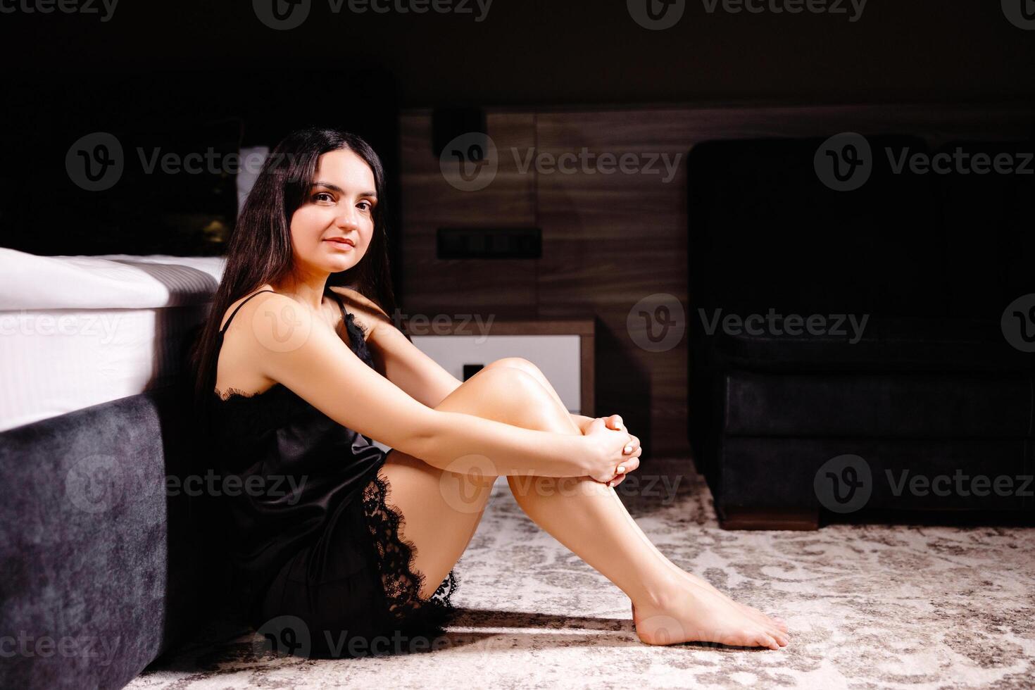 Unhappy woman touching hair, sitting on floor at home, thinking about problems. Upset girl feeling lonely and sad, psychological and mental troubles, suffering from bad relationship or break up photo