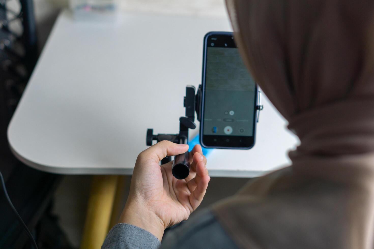 Woman with hijab preparing the recording mobile phone to make a and produce content photo