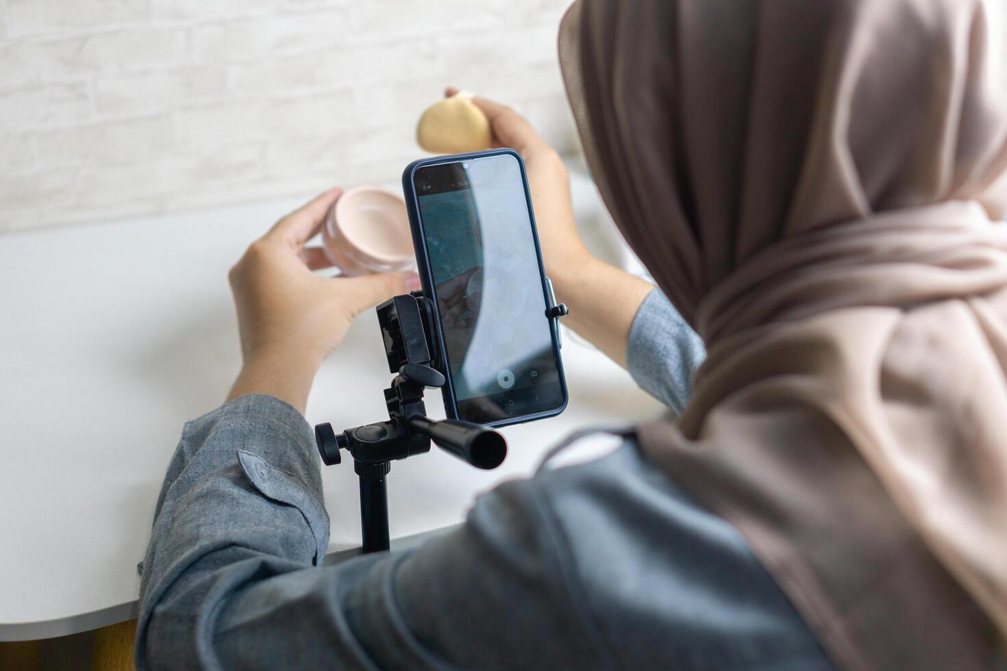 Woman with hijab preparing the recording mobile phone to make a and produce content photo
