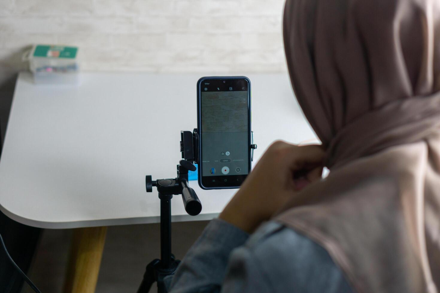 Woman with hijab preparing the recording mobile phone to make a and produce content photo
