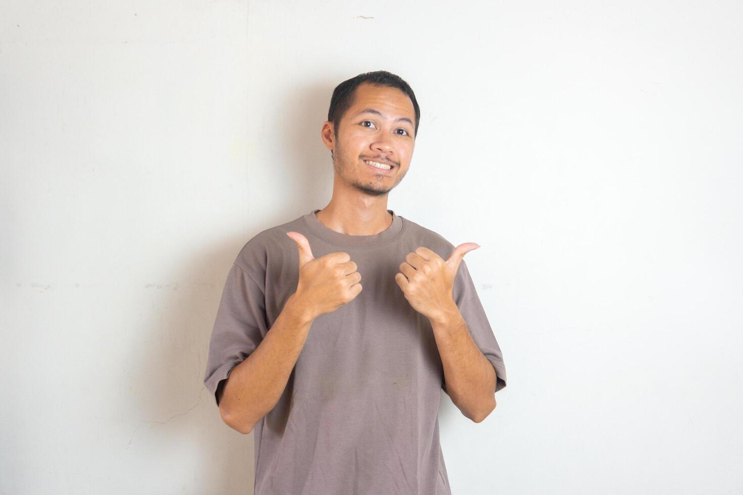 Young men wearing purple shirt smiling with thumbs up on isolated white background photo