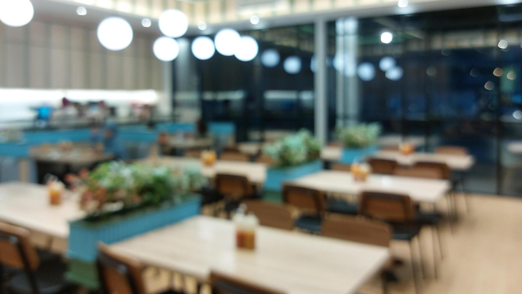 Blurry background of restaurant. Customer is waiting for food and waiters are ready to serve photo