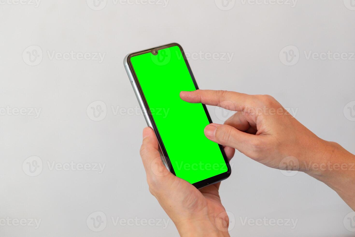 women hand holding smart mobile phone with blank green screen on isolated white background photo