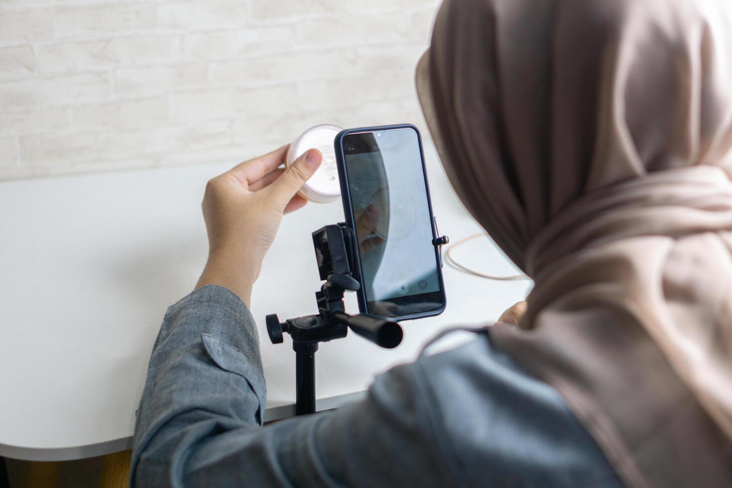Woman with hijab preparing the recording mobile phone to make a and produce content photo