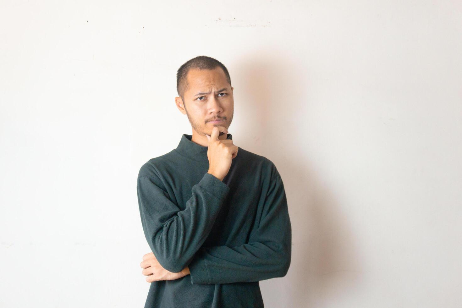 Young men wearing warm clothes is thingking something on isolated white background photo
