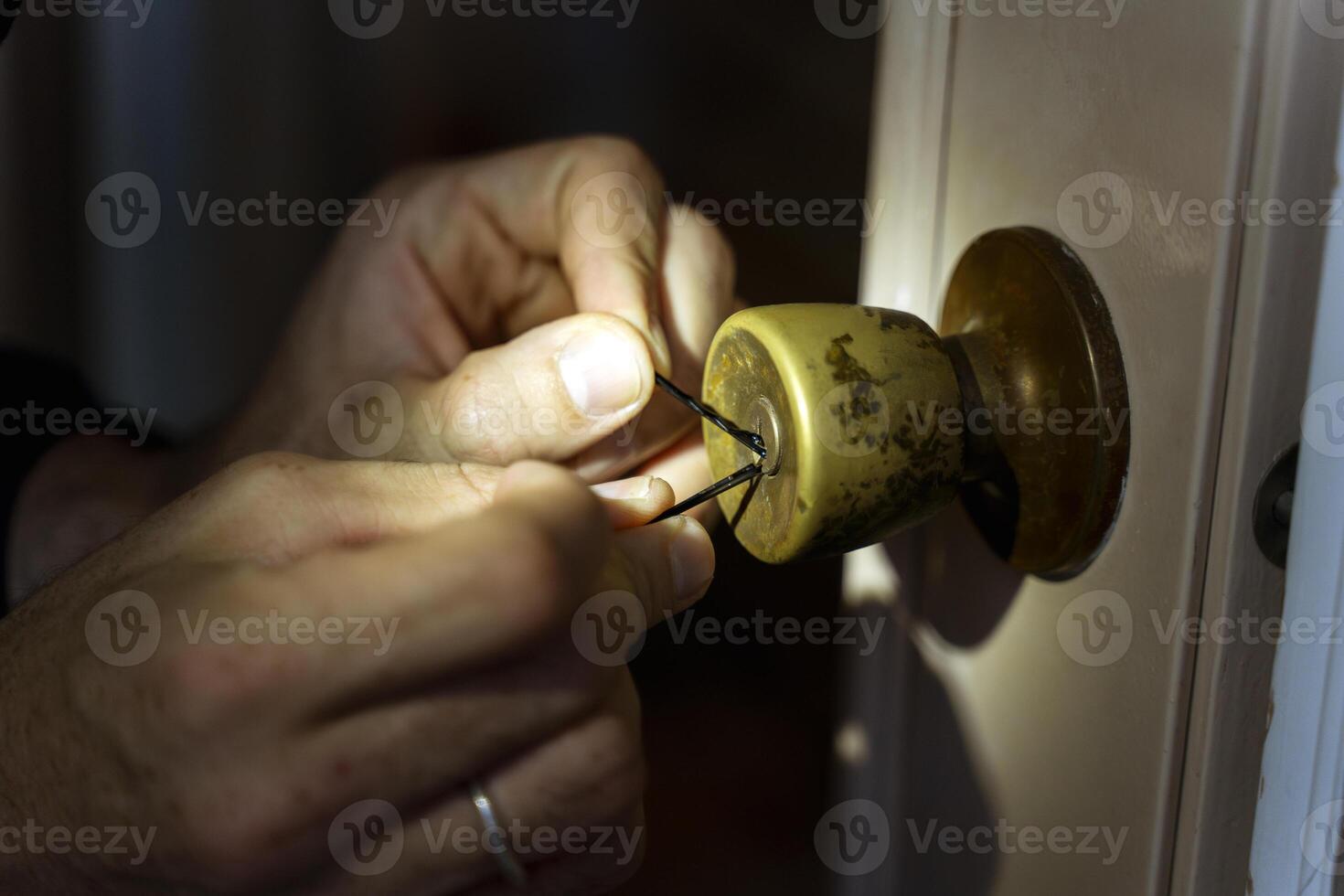 Person is picking a lock with a tool photo