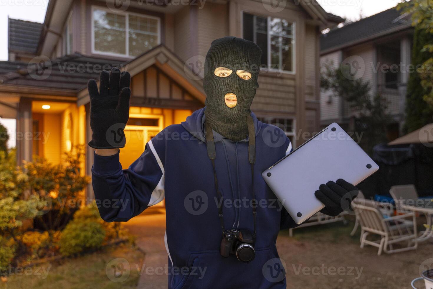 Shocked burglar being caught stealing from suburban home photo