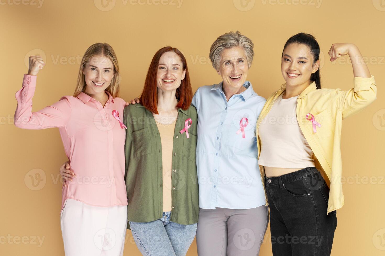 Group of women showing strength with pink ribbons for breast cancer awareness photo