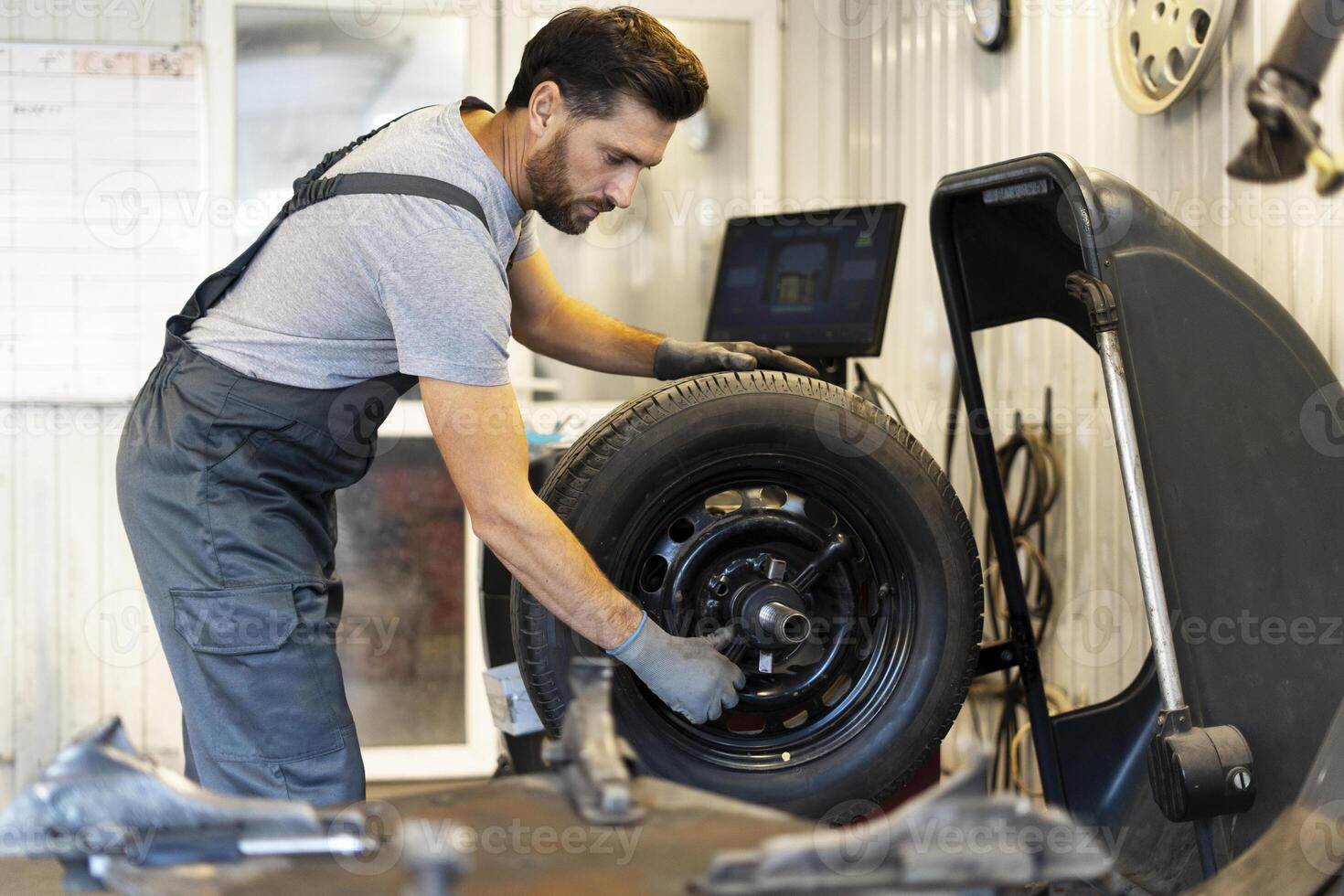 Mechanic mounting tire on wheel rim using professional equipment photo