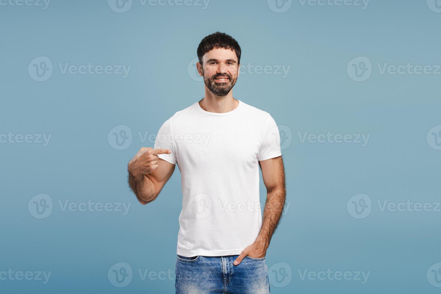 Portrait of handsome, smiling, bearded man wearing stylish white t shirt, pointing finger, mock up photo