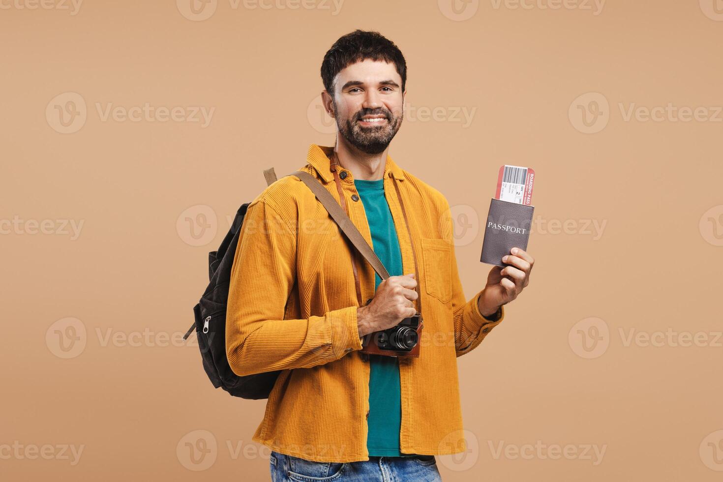 Smiling, attractive bearded man, traveler holding backpack and passport with ticket, looking away photo