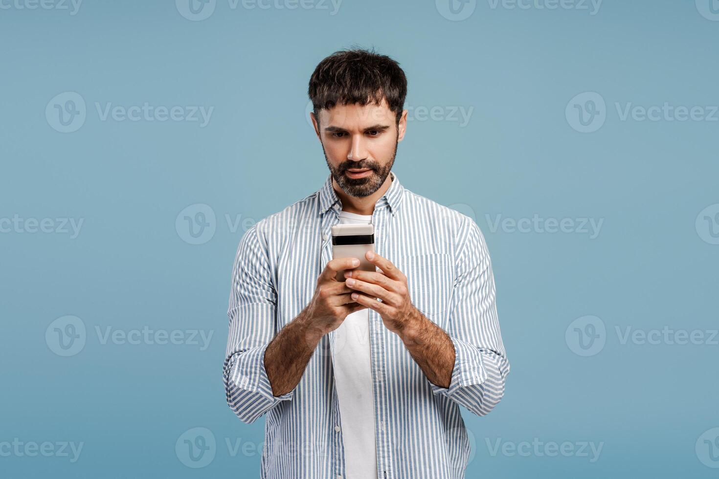 Pensive, middle aged, bearded man holding mobile phone, using mobile app, social media concept photo