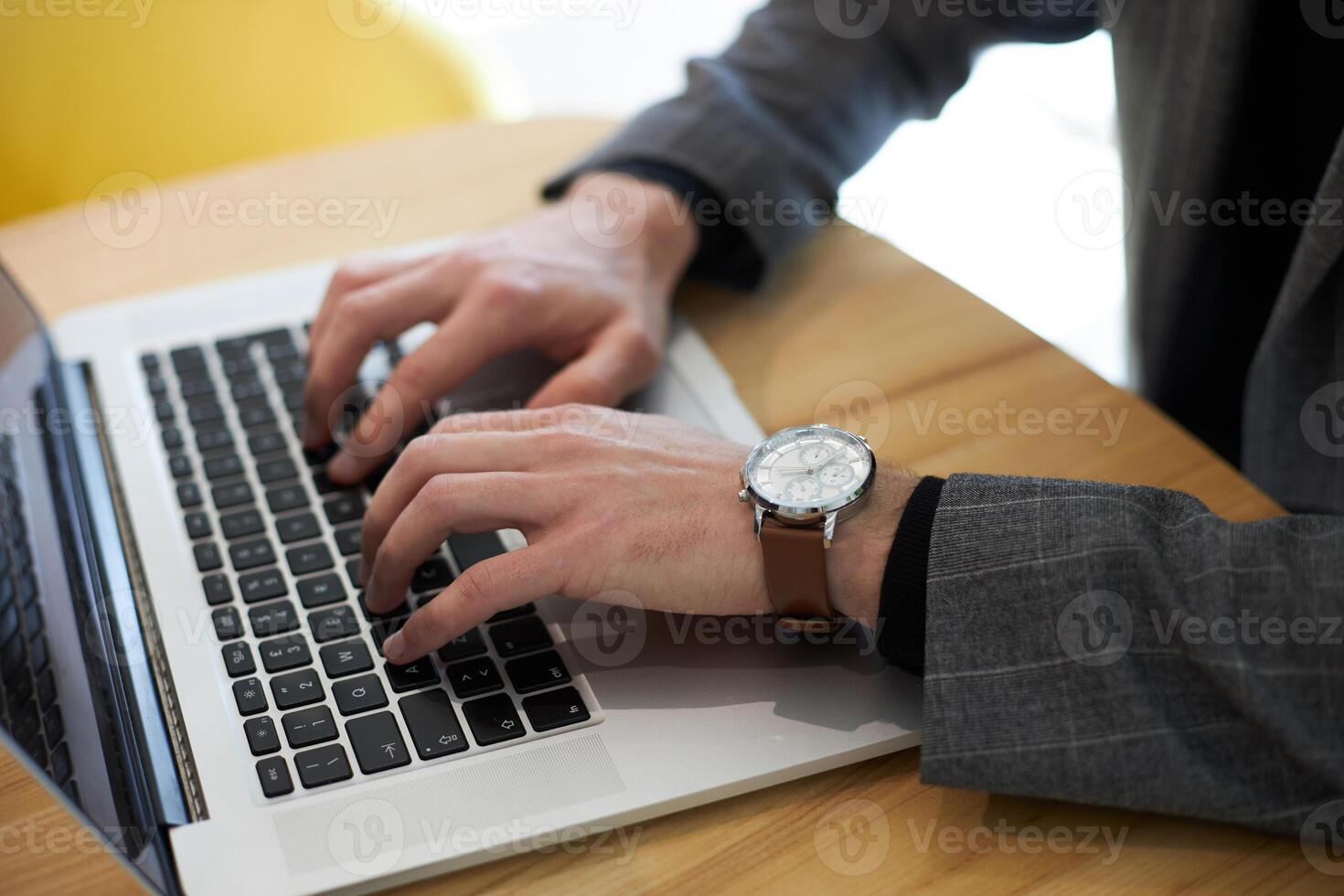 Businessman working on laptop computer in office typing on keyboard photo