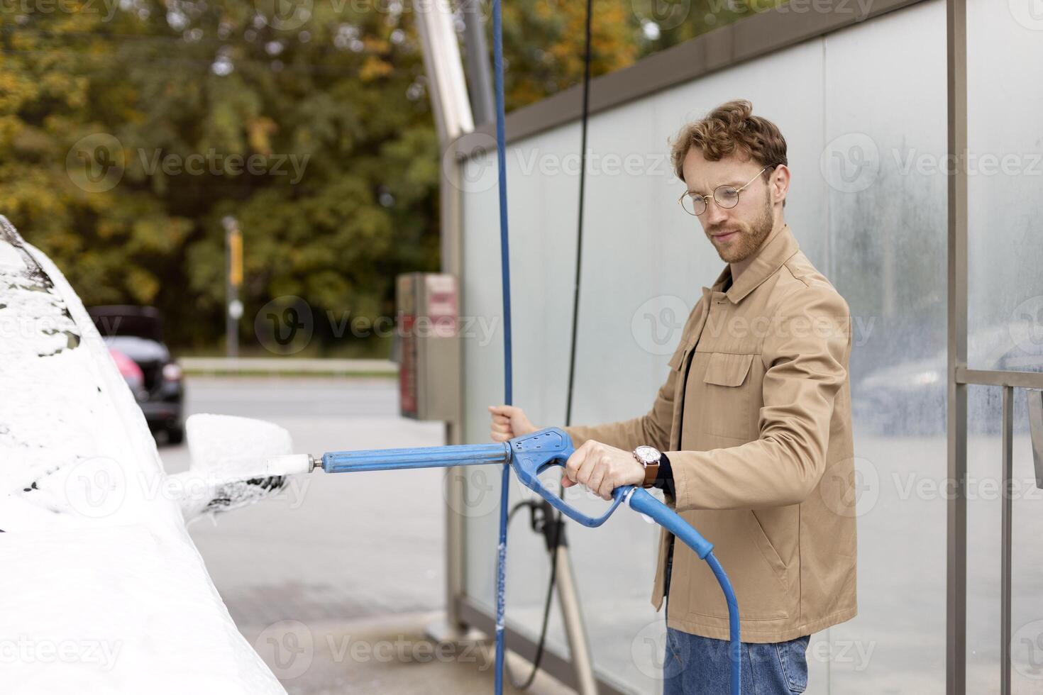 Man washing his car in a self service car wash station photo