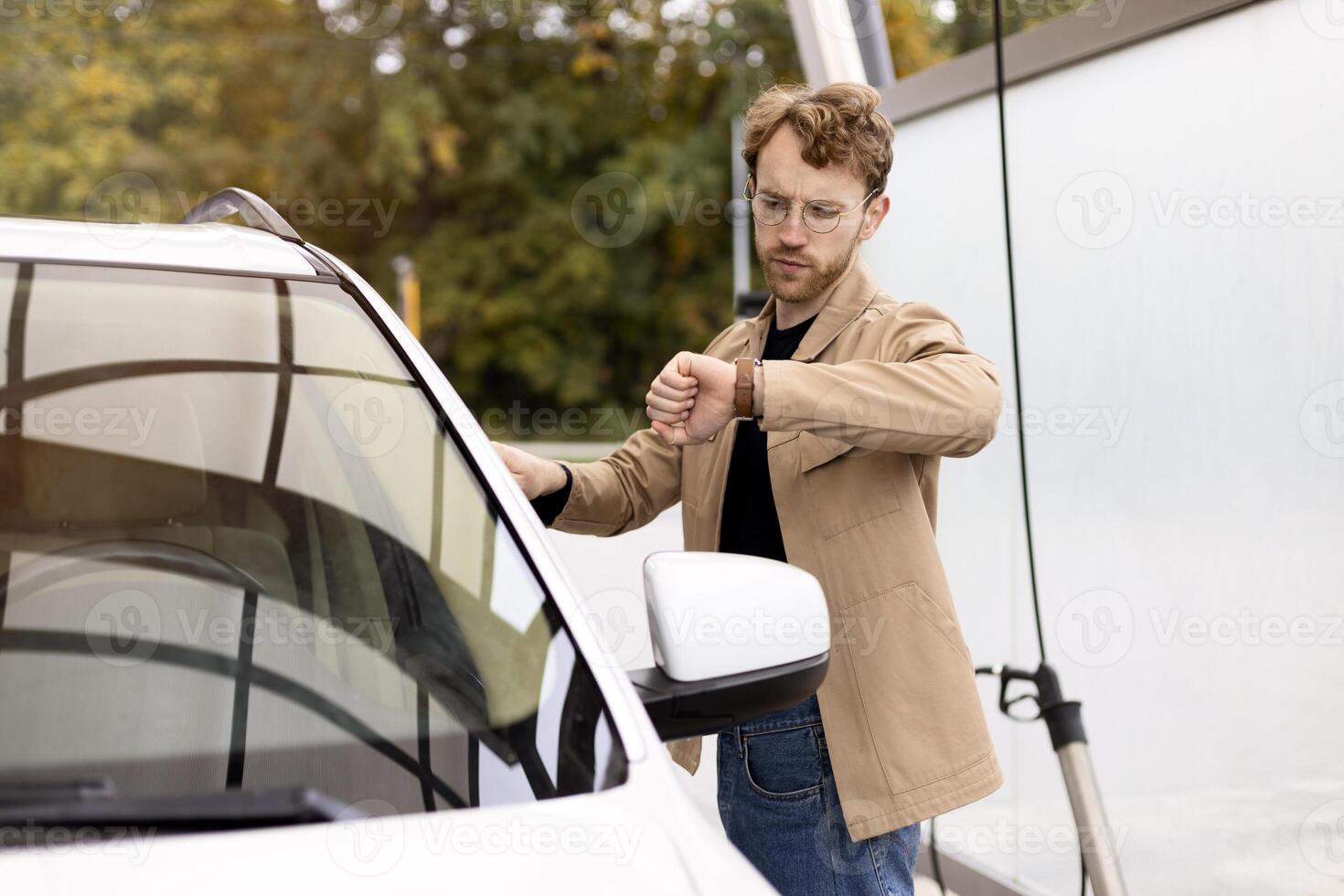 Impatient driver checking time while waiting at car wash photo