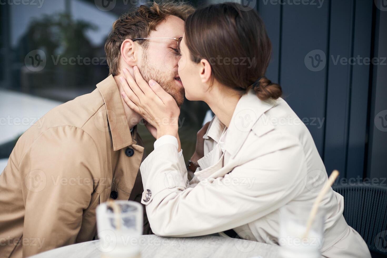 Young couple kissing at cafe table on a date photo