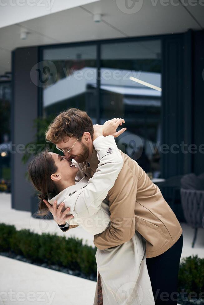 Young couple embracing while leaning in for kiss photo