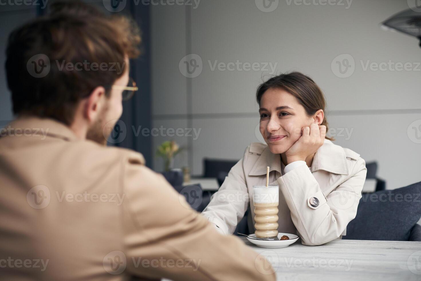 Young woman listening attentively while having coffee at the cafe photo
