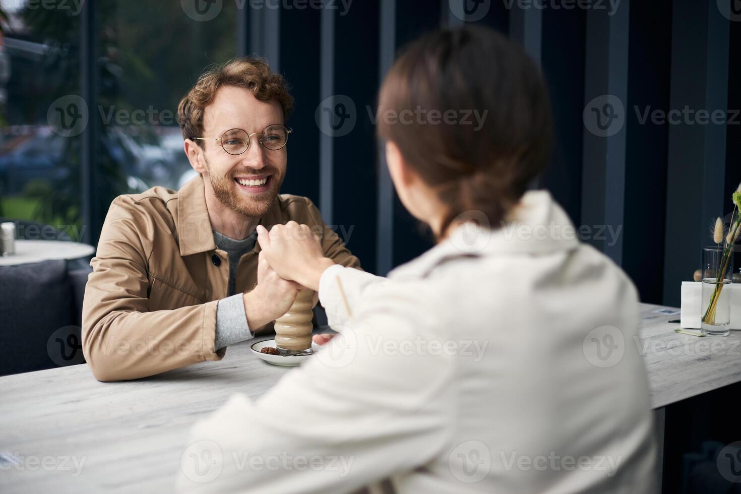 Happy couple holding hands while having coffee at the cafe photo