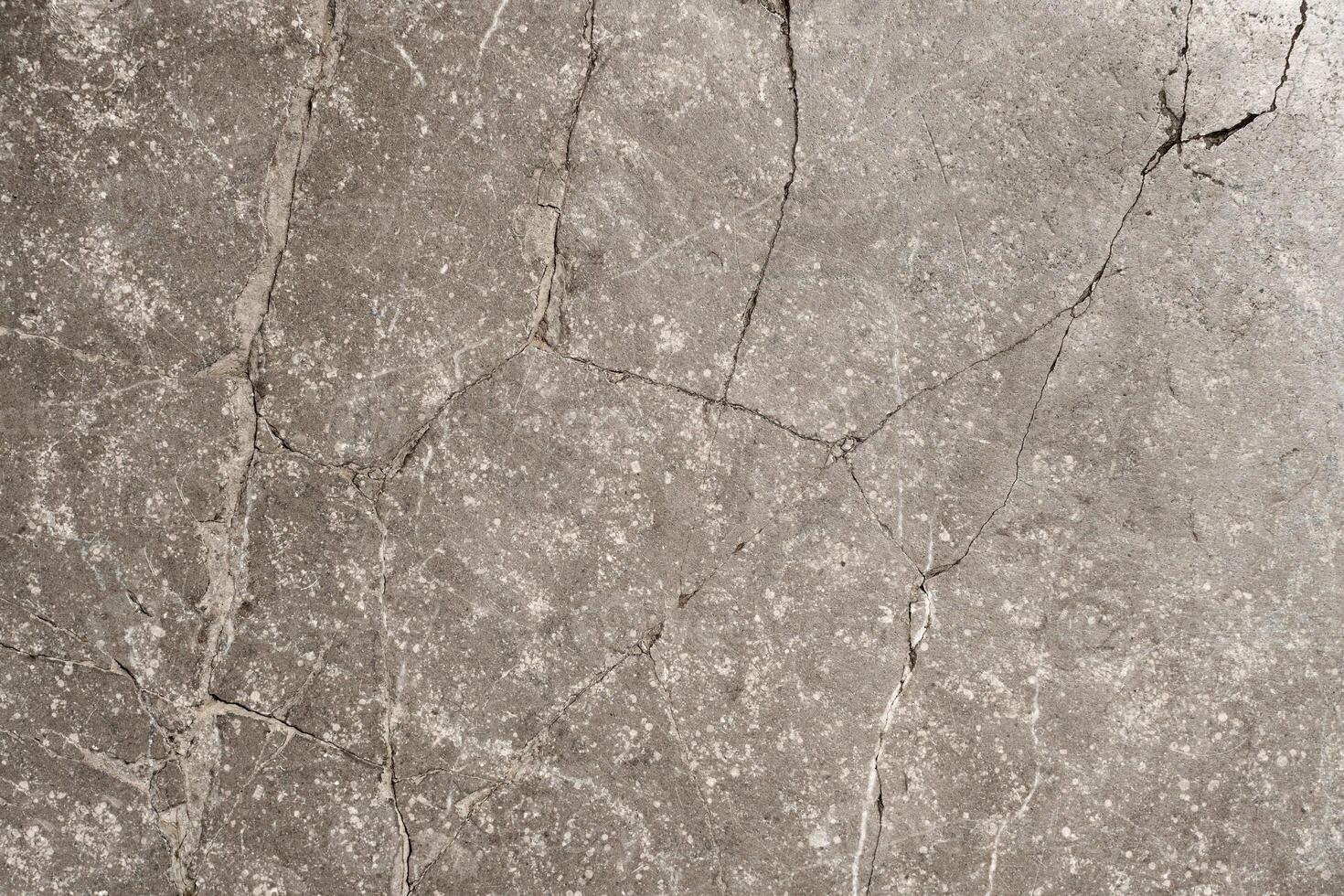 Cracked stone surface forming abstract pattern texture background photo