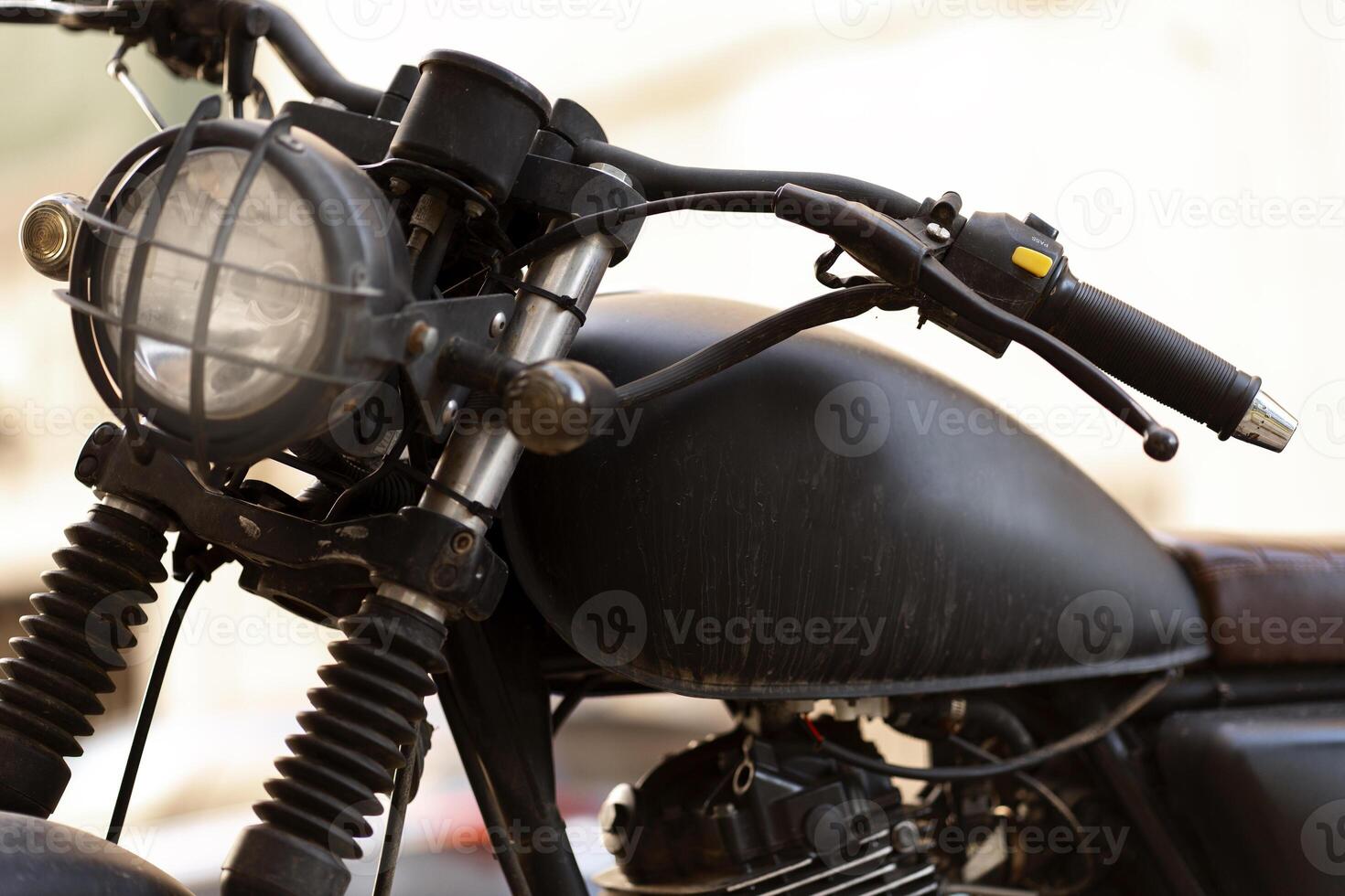 Black motorcycle parked on the street is reflecting the sun in urban scenery photo