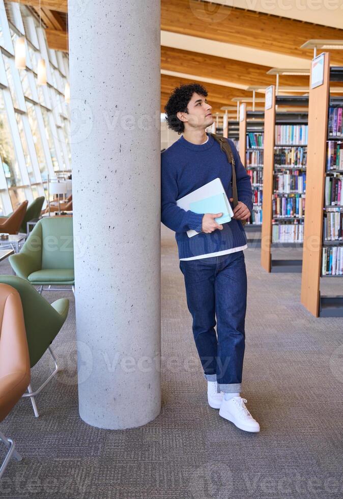 Thoughtful university student planning next class in library photo