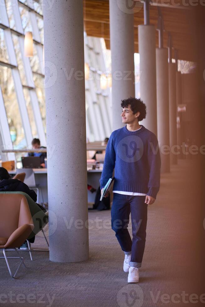 Smiling university student walking in modern library building photo