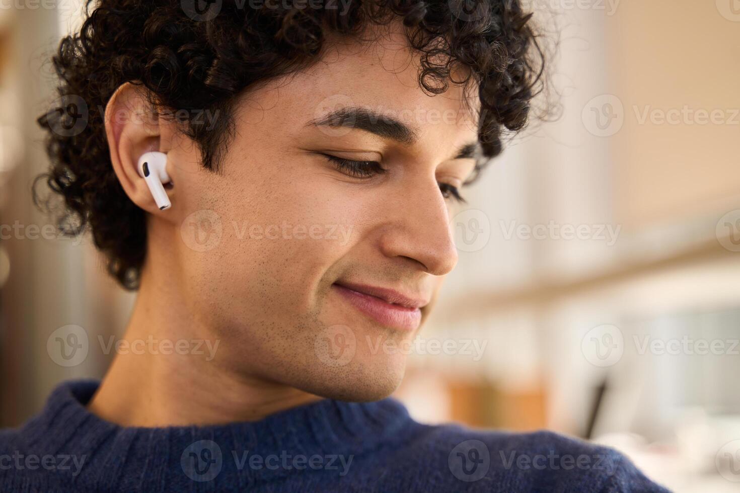 Young man wearing wireless earphones listening to music photo