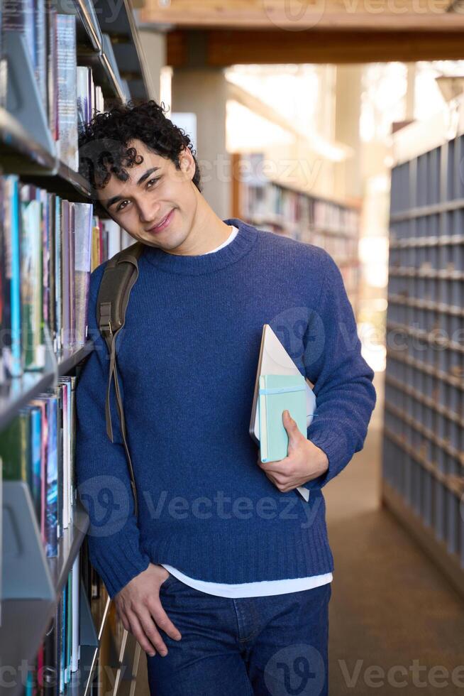 Young student relaxing in the library between classes photo