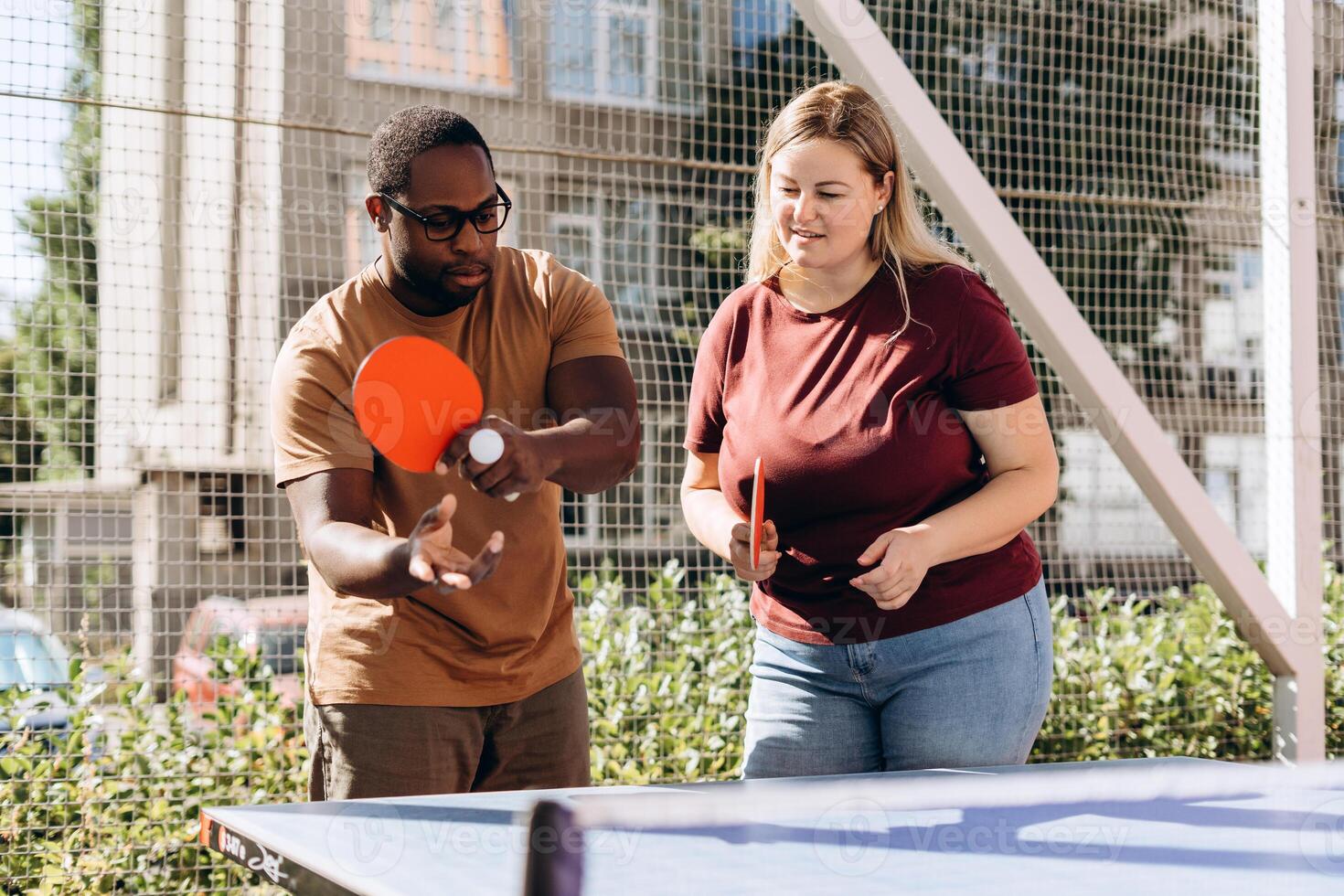 Happy people playing table tennis outdoors, having fun photo