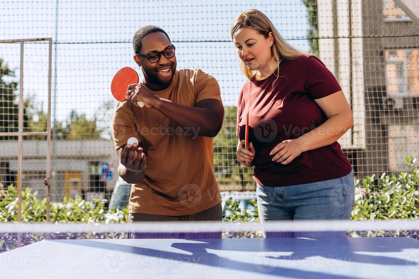 Happy multiracial friends playing ping pong table tennis, having fun together photo