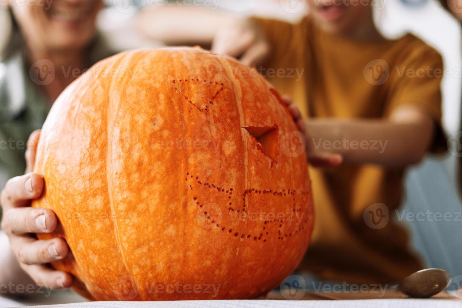 Family carving a big orange pumpkin for halloween celebration photo