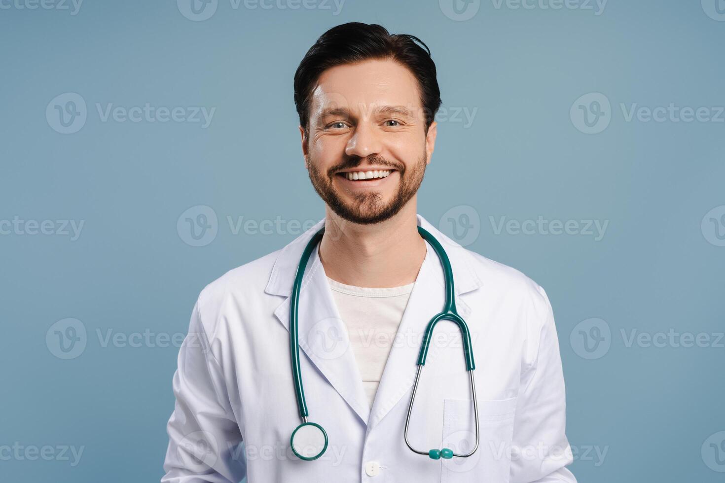 Happy doctor, smiling attractive man smiling wearing white coat and stethoscope photo