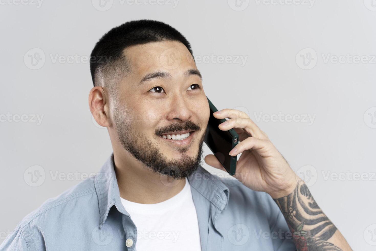Smiling young man talking on mobile phone having pleasant conversation photo