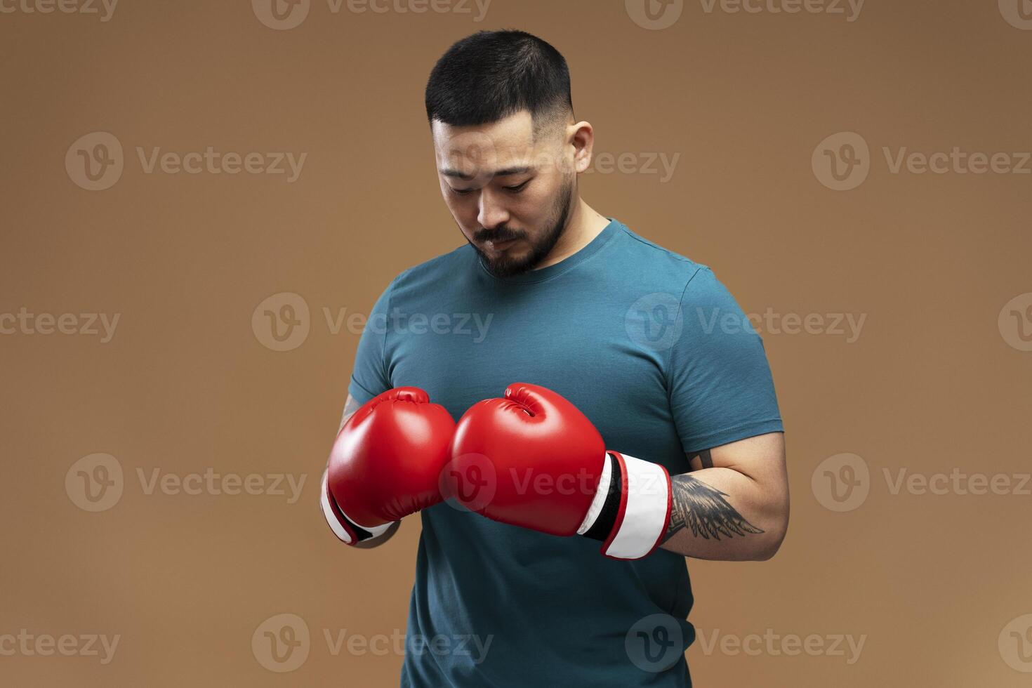 Asian boxer wearing red boxing gloves preparing for fight photo