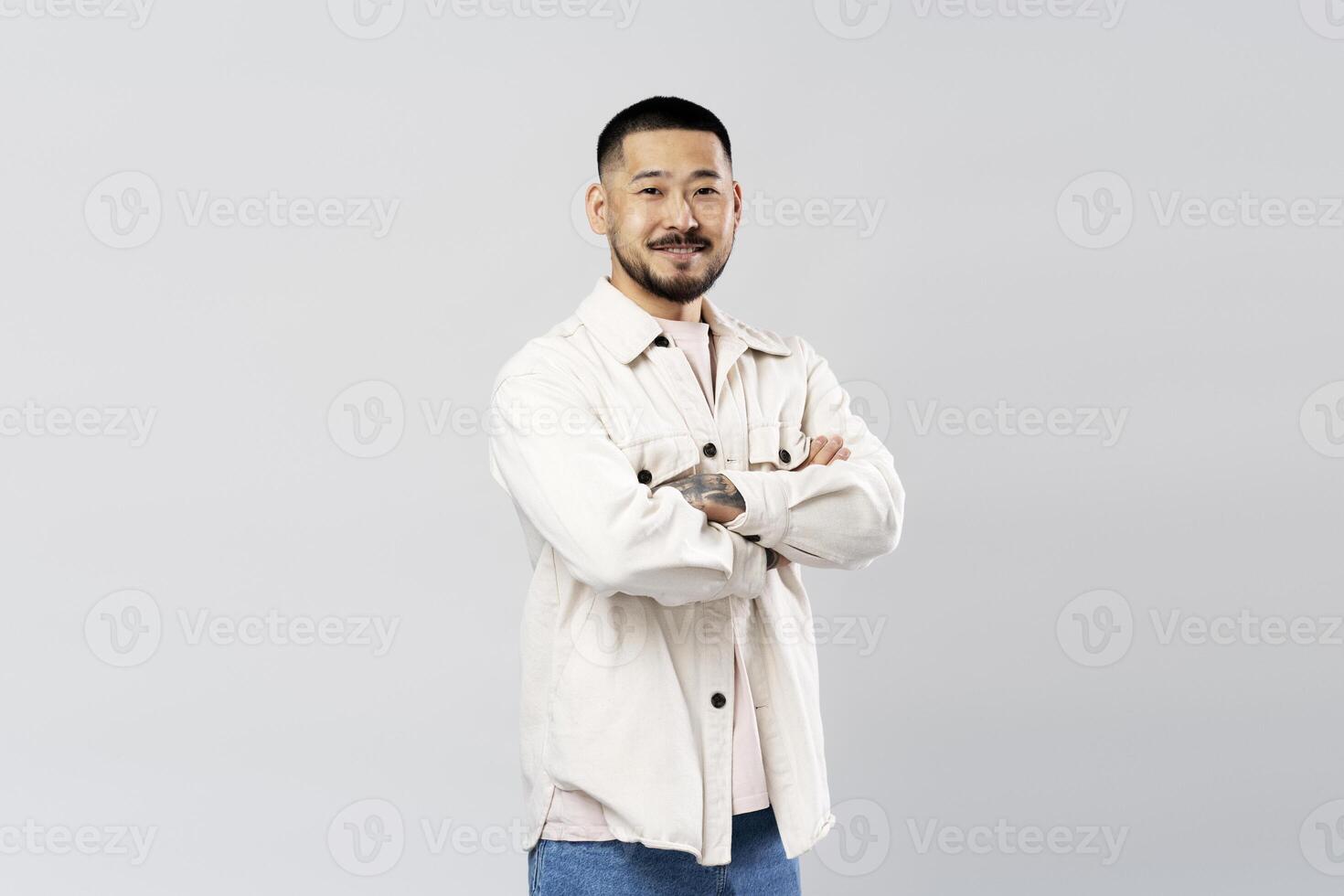 Asian man smiling with arms crossed on white background photo
