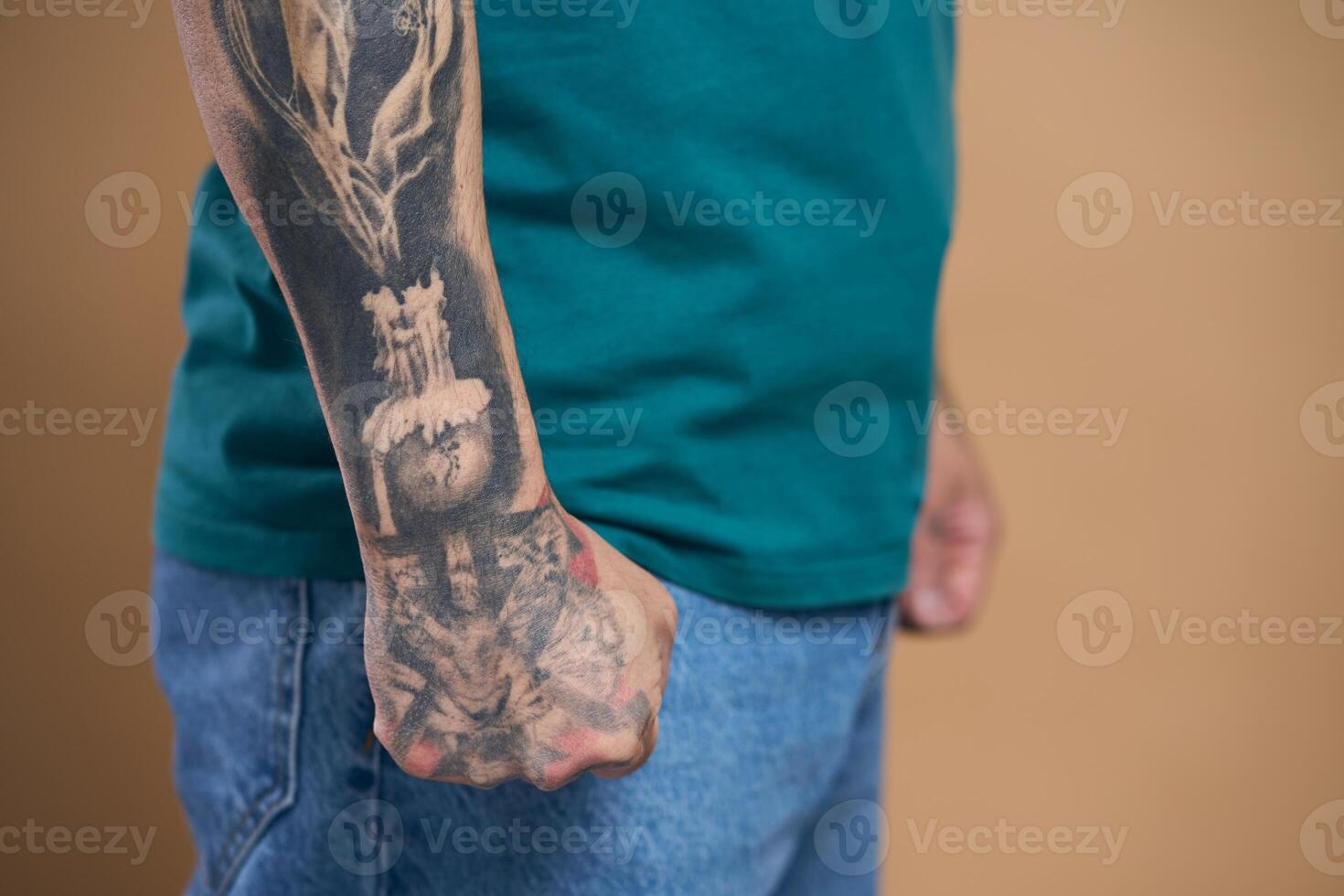 Man showing tattooed arm and clenched fist photo