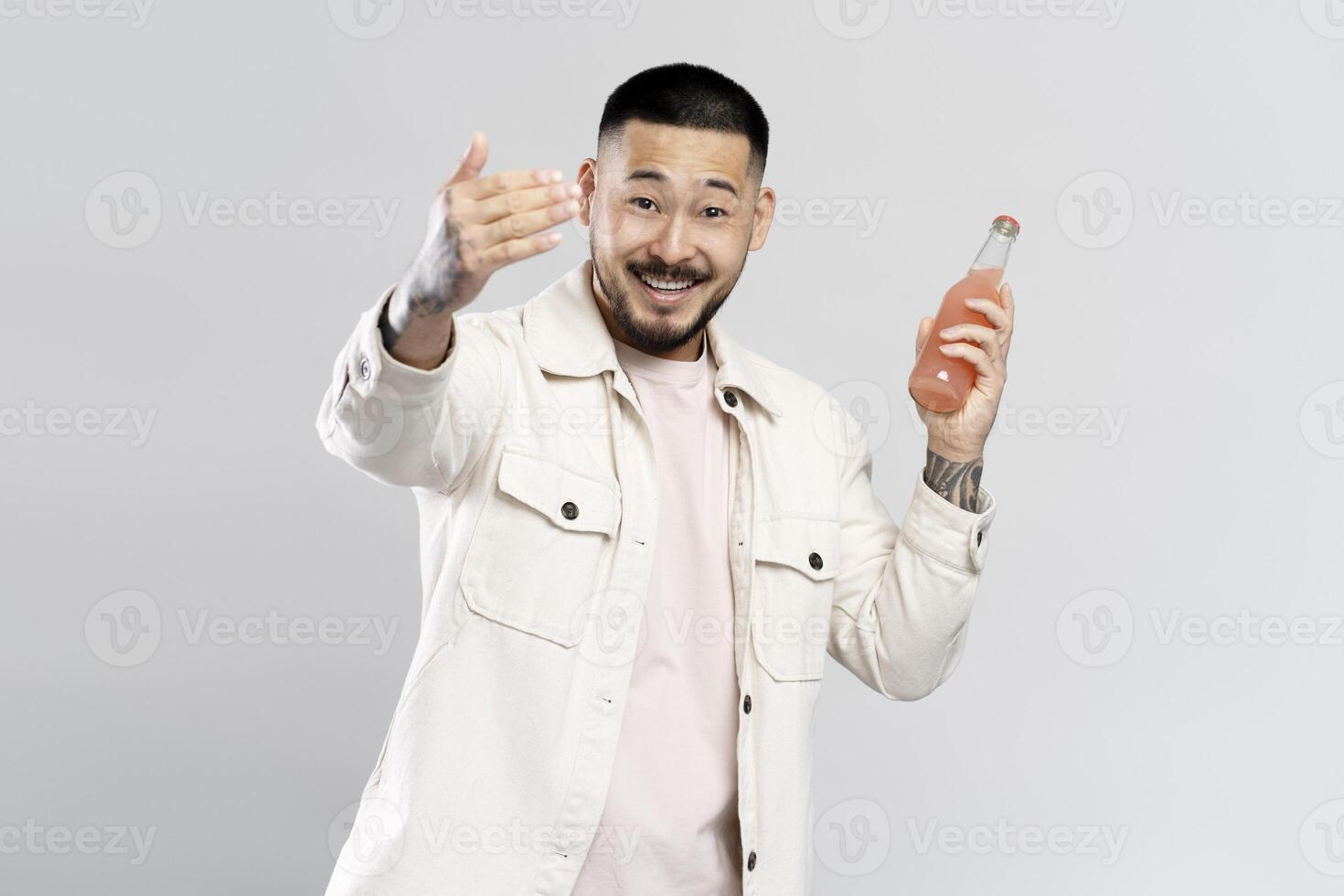 Young man holding pink drink inviting to join party photo