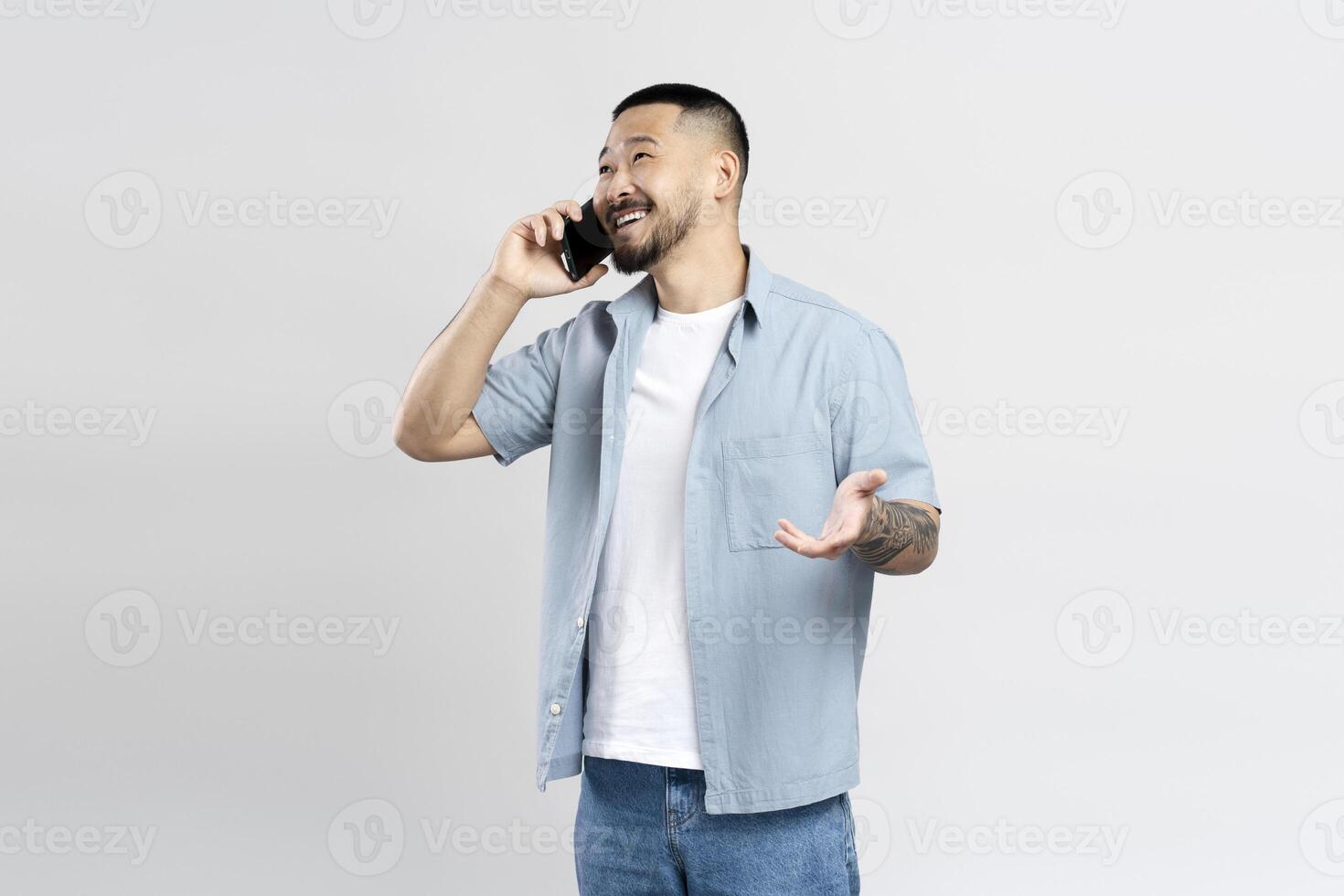 Young man having phone conversation gesturing with hand photo
