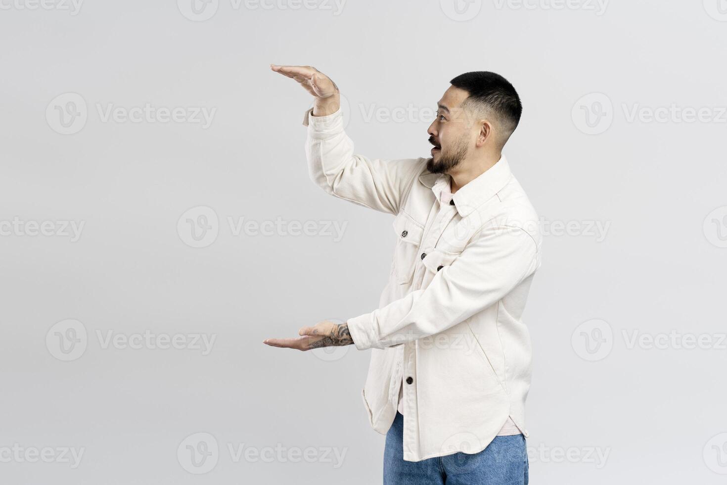 Excited man showing something big with hands on white background photo